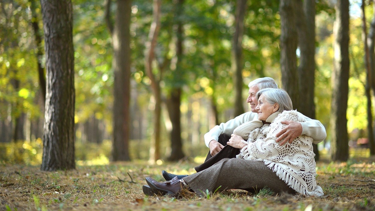 Beautiful happy old people sitting in the autumn park